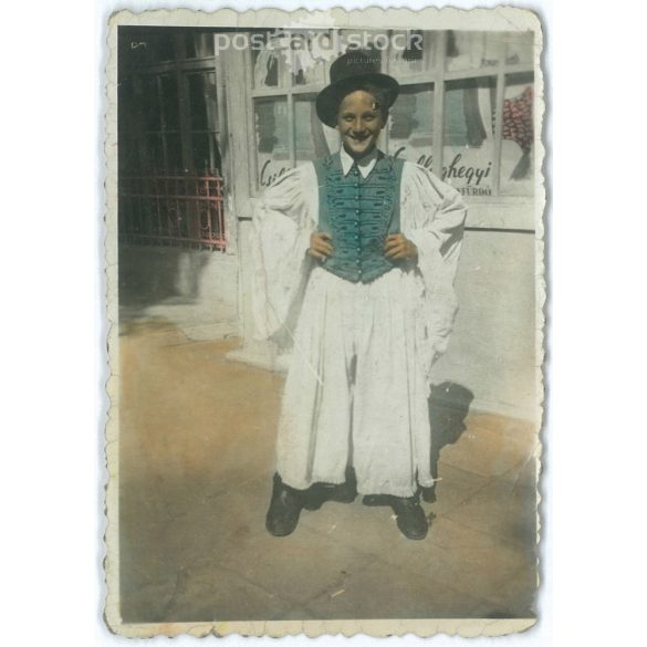 Fiatal fiú népviseletben, a Csillaghegyi fürdő előtt. Színes papírkép. (2791832)