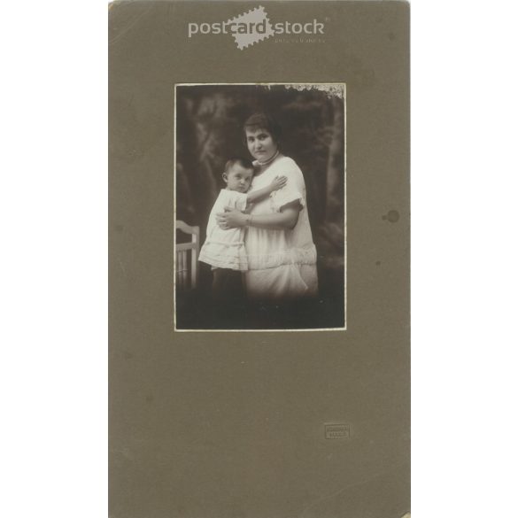 1910-es évek. Édesanya gyermekével, műtermi felvétel. Készült Homonnai, fényképészeti műtermében, Makó. Eredeti, kasírozott papírkép. (2792264)