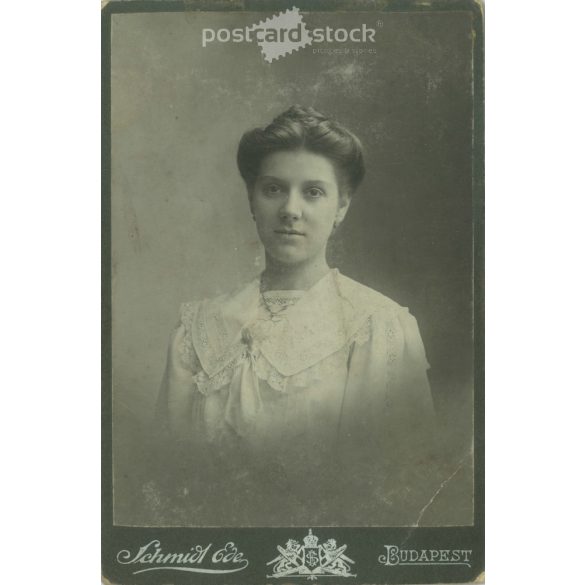 1900-as évek eleje. Fiatal nő műtermi portréfotója. Személye ismeretlen. A fotó Schmidt Ede fényképészeti műtermében készült, Budapesten. Eredeti kabinetfotó / keményhátú fotó / vizitkártya, CDV fotó. (2792350)