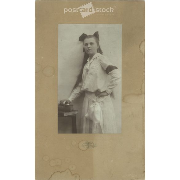 1905 – Leány masnival, fehérben. Szombathely. Fekete-fehér eredeti kasírozott papírkép, régi fotó. A képet Szilárd Tódor fényképészeti műterme készítette. (2792412)