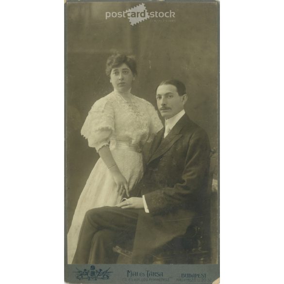 1908 október. Fiatal pár műtermi felvétele. A képen szereplők személye ismeretelen. A kép készítője Mai és Társa fényképészeti műterme. Régi fotó, eredeti kabinetfotó / keményhátú fotó. (2792783)